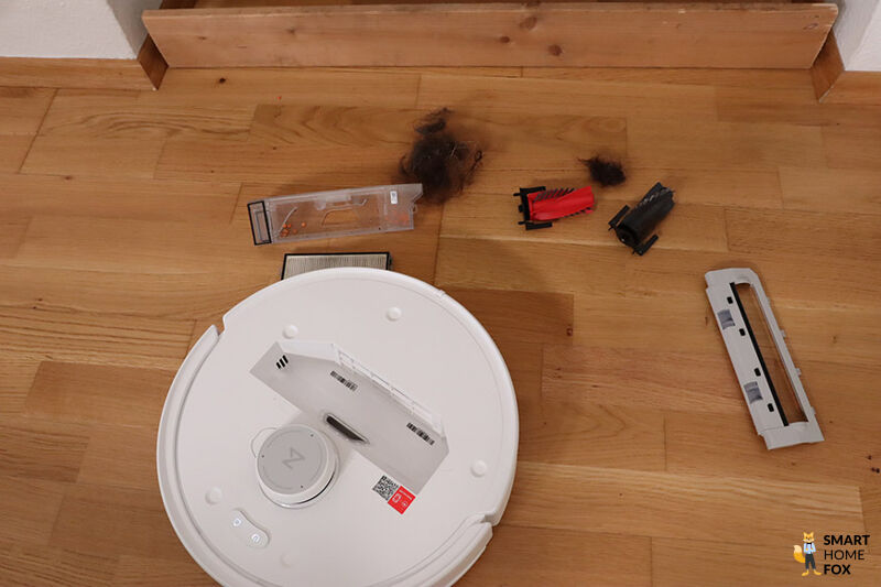 Die Einzelteile des Roborock QRevo Curv liegen einzeln auf dem Parkett